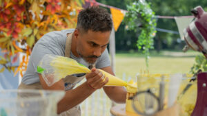 Shai met spuitzak in zijn hand in de tent